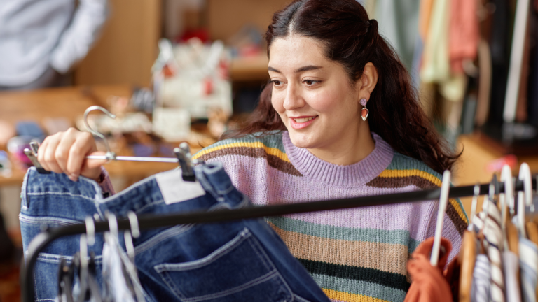 jonge dame bekijkt tweedehands kleding